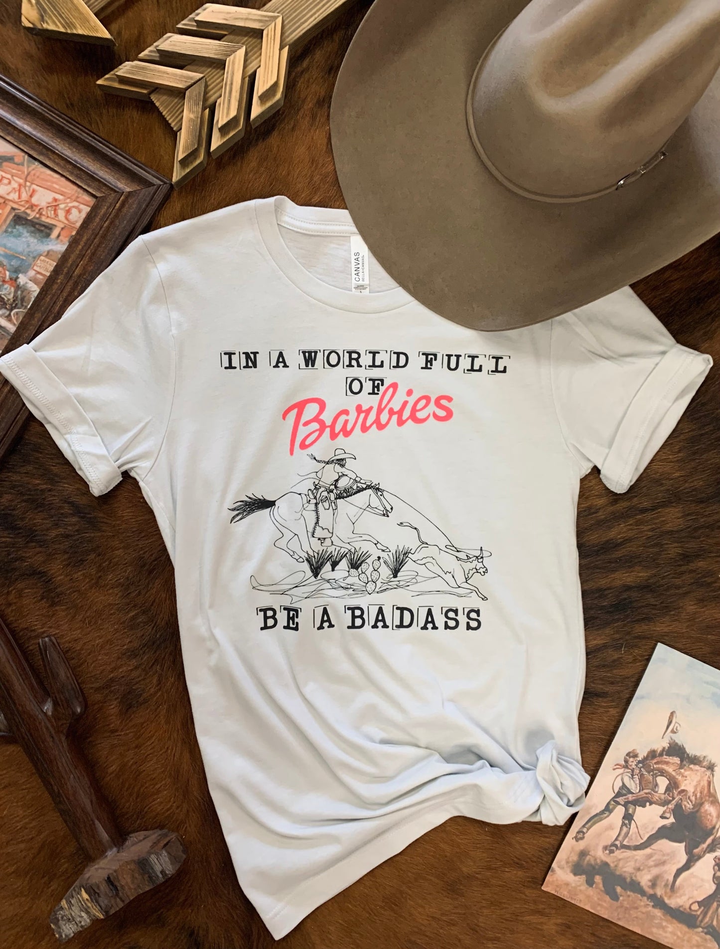 In A World Full of Barbies Be A Badass Western Graphic Tee